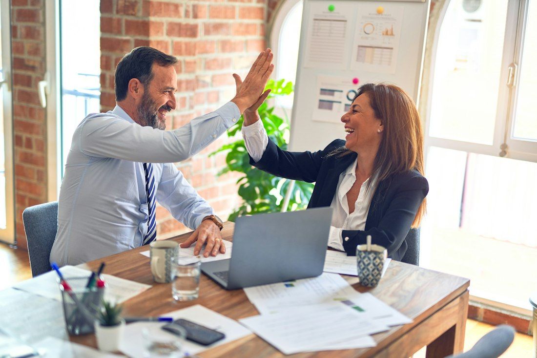 Two colleagues celebrating at their desk